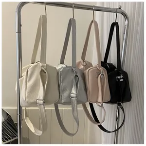 Détail de sacs fourre-tout en beige, argent, rose et noir sur un support métallique