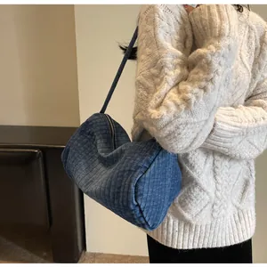 Detailed close-up of dark blue corduroy fabric texture and zipper on shoulder bag