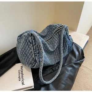 Detailed view of blue washed denim shoulder bag with vertical stripe texture and metal zipper