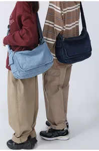 Detail of light and dark blue denim messenger bags with adjustable straps and large capacity