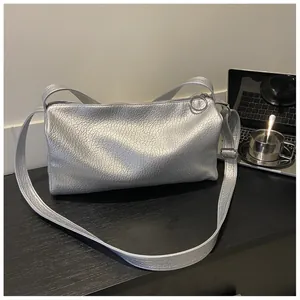 Détail du sac cabas argenté avec texture froissée, fini métallisé et fermeture à anneau