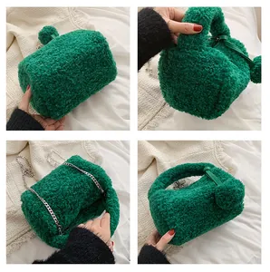 Detail view of emerald green plush handbag with silver chain strap and faux fur texture
