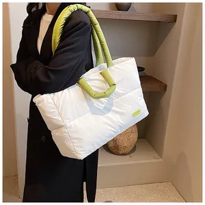 Dettaglio della borsa tote trapuntata con manici verdi e toppa con logo alla moda