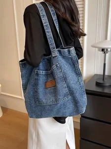 Large blue denim tote bag for women with leather logo patch and casual shoulder straps