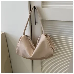 Vue détaillée du sac beige texturé avec fermetures éclair argentées et profil souple