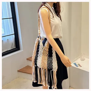 Detail of woven straw shoulder bag with tassels and wooden beads in bohemian style