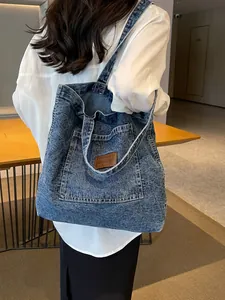 Classic washed blue denim tote bag with leather logo patch and spacious shoulder design