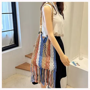 Detail of handmade woven tassel shoulder bag with blue and white stripes in bohemian style