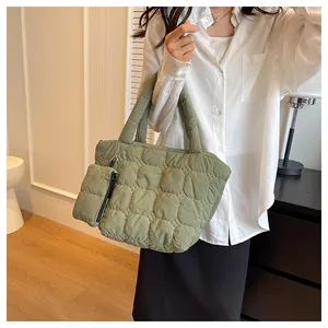 Detailed view of an olive green quilted tote bag with matching mini coin purse detail