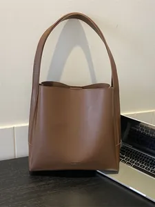 Minimalist deep brown leather tote bag for women, spacious shoulder bucket bag for office use