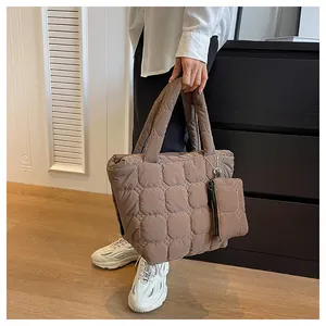 Macro detail of brown quilted puffer tote bag with detachable mini zipper coin pouch