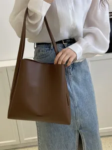 Minimalist dark brown leather tote bag with large capacity shown on model