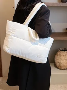 Borsa tote imbottita trapuntata bianco avorio con etichetta fashion su una modella
