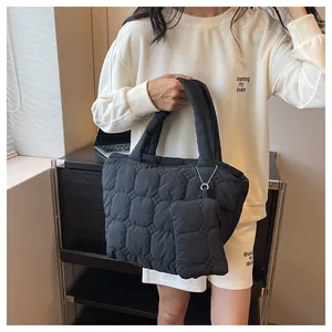 Close-up of black quilted bubble tote bag and matching mini pouch for daily commuting