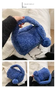Close-up of blue plush faux fur handbag with fluffy pom-pom charm and silver chain strap