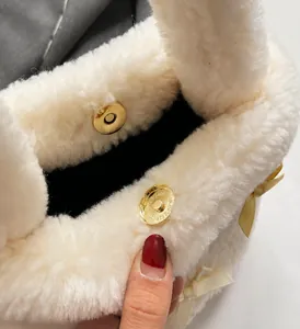 Close-up of golden magnetic closure and white faux fur texture on the bucket bag