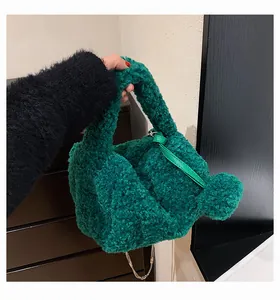 Detail of green plush handbag featuring soft faux fur texture and slim metal chain strap