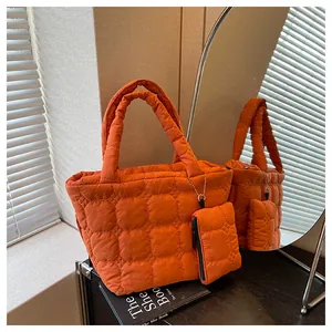 Detailed view of the bright orange quilted tote bag with matching zippered pouch charm