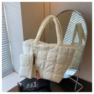 Detail of beige quilted tote bag with matching mini pouch and soft padded texture