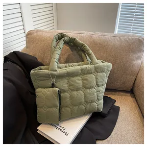Detail of green quilted tote bag with mini pouch showing geometric floral stitching