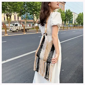 Detail of bohemian woven mesh bag with fringe tassels and wooden bead strap accents