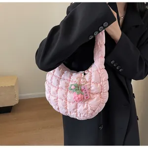 Detailed shot of pink quilted puff bag featuring a strawberry knit charm decoration