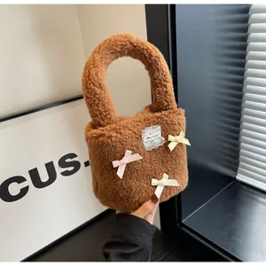 Detailed close-up of brown faux shearling bucket bag with colorful satin bows and lace label