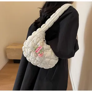 Detail of white quilted puff cloud bag with a cute handmade strawberry crochet charm