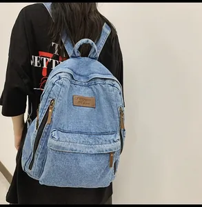 Back view of a person wearing a vintage blue denim backpack with premium leather labels