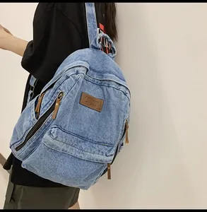 Light blue washed denim backpack shown from side-back view on a person for travel