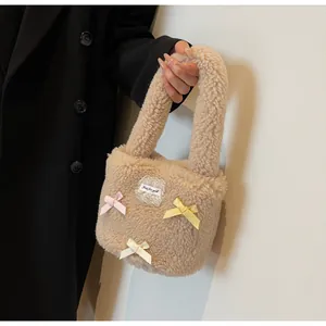 Close-up of beige faux shearling bucket bag with colorful bows and lace label detail