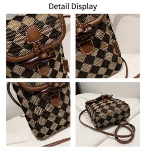 Detail view of checkered tweed phone bag with leather strap and horn toggle closure