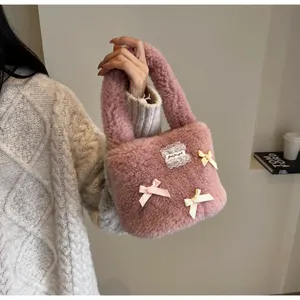 Detail of pink faux fur bucket bag with decorative silk bows and lace embroidery label
