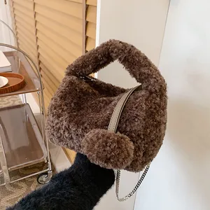 Brown fuzzy plush handbag with metal chain and pompom detail for autumn winter style