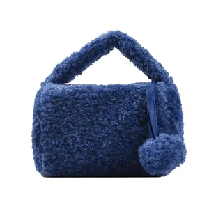 Navy blue faux fur handbag for women with plush ball charm and top handle design