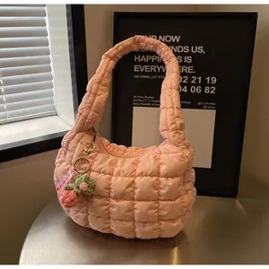 Detail of pink quilted hobo cloud bag with a handcrafted woven flower charm