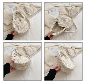 Détail d'un sac à main tissé rond avec coutures colorées, bandoulière et pendentif en bois