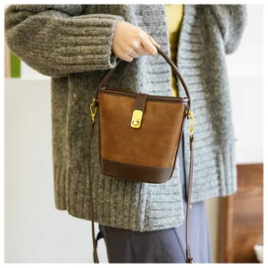 Detailansicht der braunen Vintage-Beuteltasche mit Goldverschluss und Lederriemen