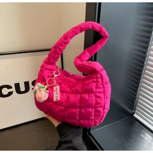 Close-up of rose red quilted cloud bag with cute strawberry charm and text detail