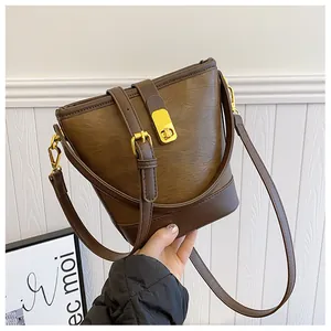 Detailansicht der dunkelbraunen Eimertasche mit goldenen Beschlägen und Kunstledertextur