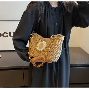 Detalle del bolso de hombro de paja tejida con margaritas 3D y cadena de acrílico