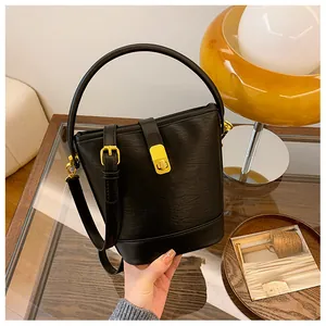 Detail einer schwarzen Lederbeuteltasche mit goldener Hardware und einem runden Griff