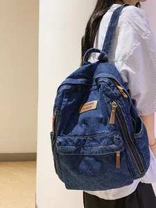 Vintage dark blue denim backpack for school and travel shown from a rear-side view