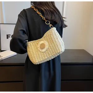 Detalle de bolso de paja trenzada con flores y correa de cadena de acrílico