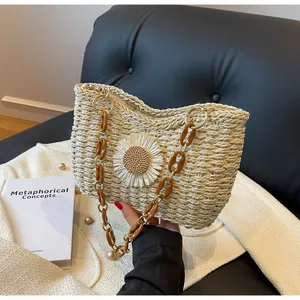 Detalle de bolso de paja con margarita blanca y correa de cadena de acrílico