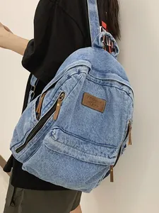Vintage light blue denim backpack featuring large capacity and stylish brown leather details