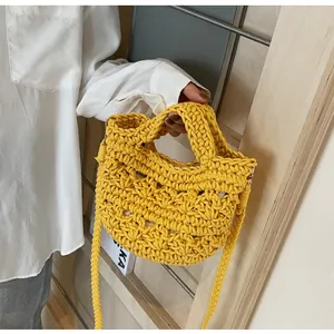 Detailed view of the bright yellow hand-woven bucket bag with thick knit texture and strap