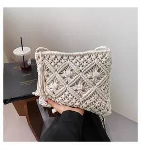 Detail of bohemian macramé phone bag featuring woven geometric patterns and side tassels