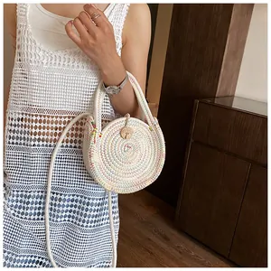 Détail du sac rond en paille multicolore avec bouton en bois et bandoulières tressées