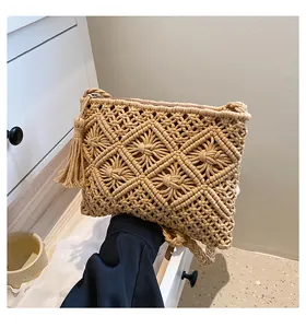 Close-up of bohemian woven cotton bag featuring tassel details and a metal zipper